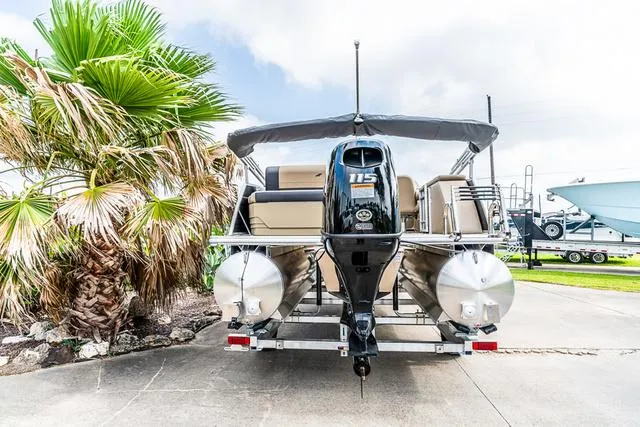 Slide: The Image of 2025 Starcraft EX20QDH pontoon boat with outboard motor, parked near palm trees. - 3