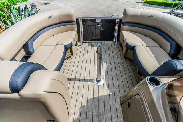 Slide: The Image of 2025 Starcraft EX20QDH pontoon boat interior with beige seating and wood-style flooring. - 8