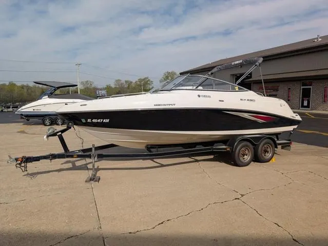 Slide: The Image of 2009 Yamaha Boats SX 230 on trailer, parked outdoors, clear sky background. - 4