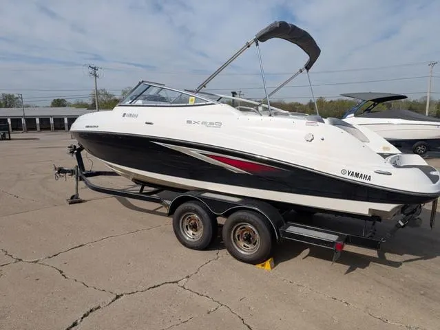 Slide: The Image of 2009 Yamaha Boats SX 230 on trailer, parked outdoors, featuring sleek black and white design. - 5
