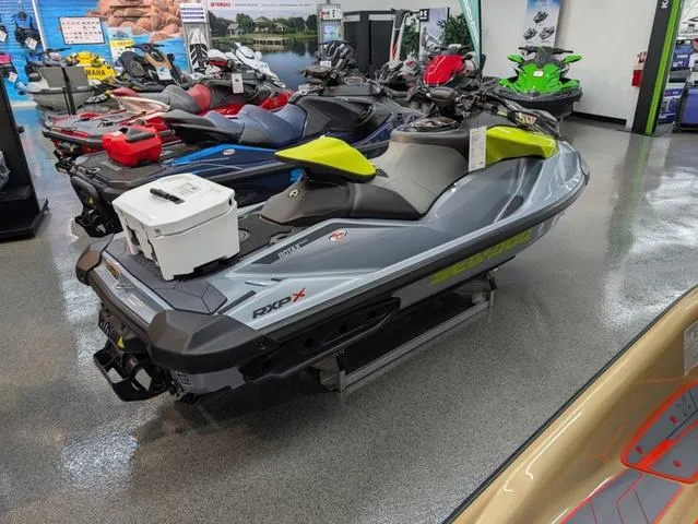 Slide: The Image of 2024 Sea-Doo RXP-X 325 Ibr in Ice Metal/Green displayed in showroom. - 3