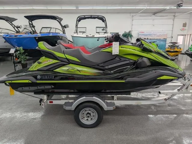 Slide: The Image of 2024 Yamaha WaveRunner FX Cruiser SVHO in showroom, vibrant green and black design on trailer. - 2