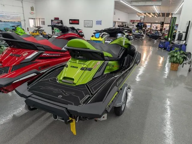 Slide: The Image of 2024 Yamaha WaveRunner FX Cruiser SVHO in showroom, green and black design, on trailer. - 3