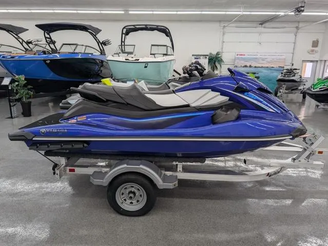 Slide: The Image of 2024 Yamaha WaveRunner GP SVHO with Audio, blue, displayed on a trailer in a showroom. - 2