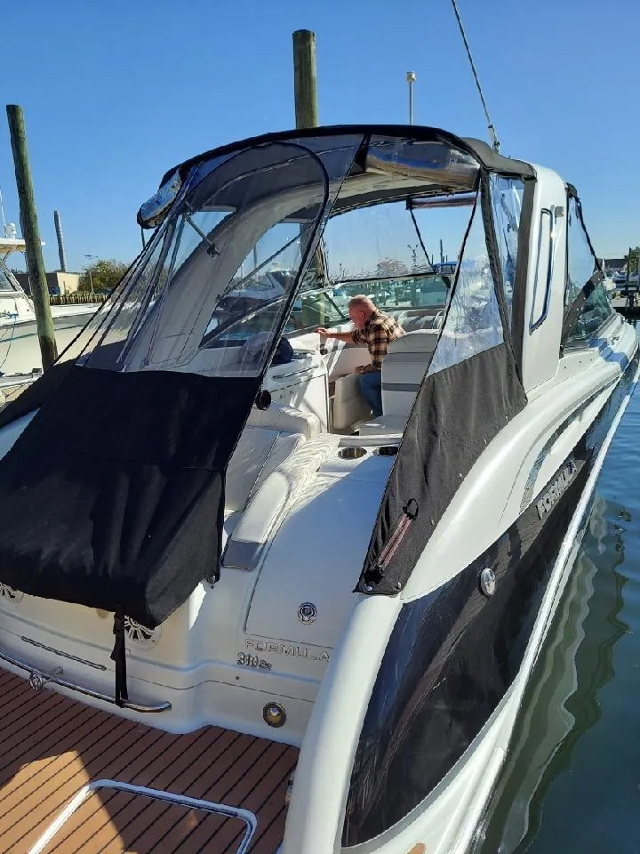 Slide: The Image of 2008 Formula 310 Bowrider boat docked, featuring sleek design and black canopy. - 10