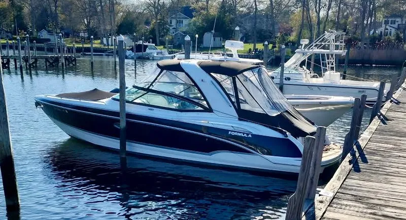 Slide: The Image of 2008 Formula 310 Bowrider docked at a marina, surrounded by calm water and trees. - 18