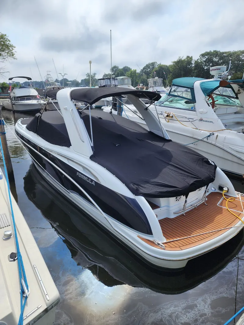 Slide: The Image of 2008 Formula 310 Bowrider boat docked with cover, featuring sleek design and spacious deck. - 3