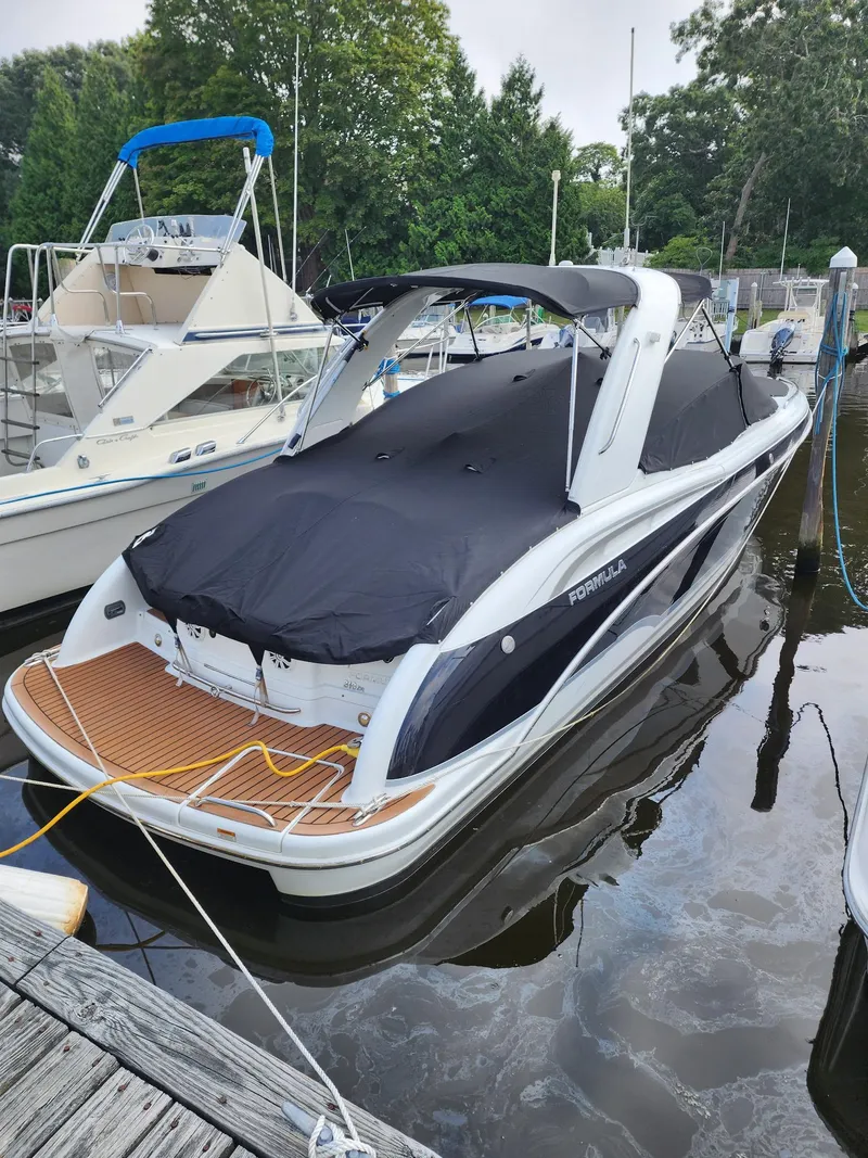 Slide: The Image of 2008 Formula 310 Bowrider boat docked with cover, featuring sleek design and spacious deck. - 4