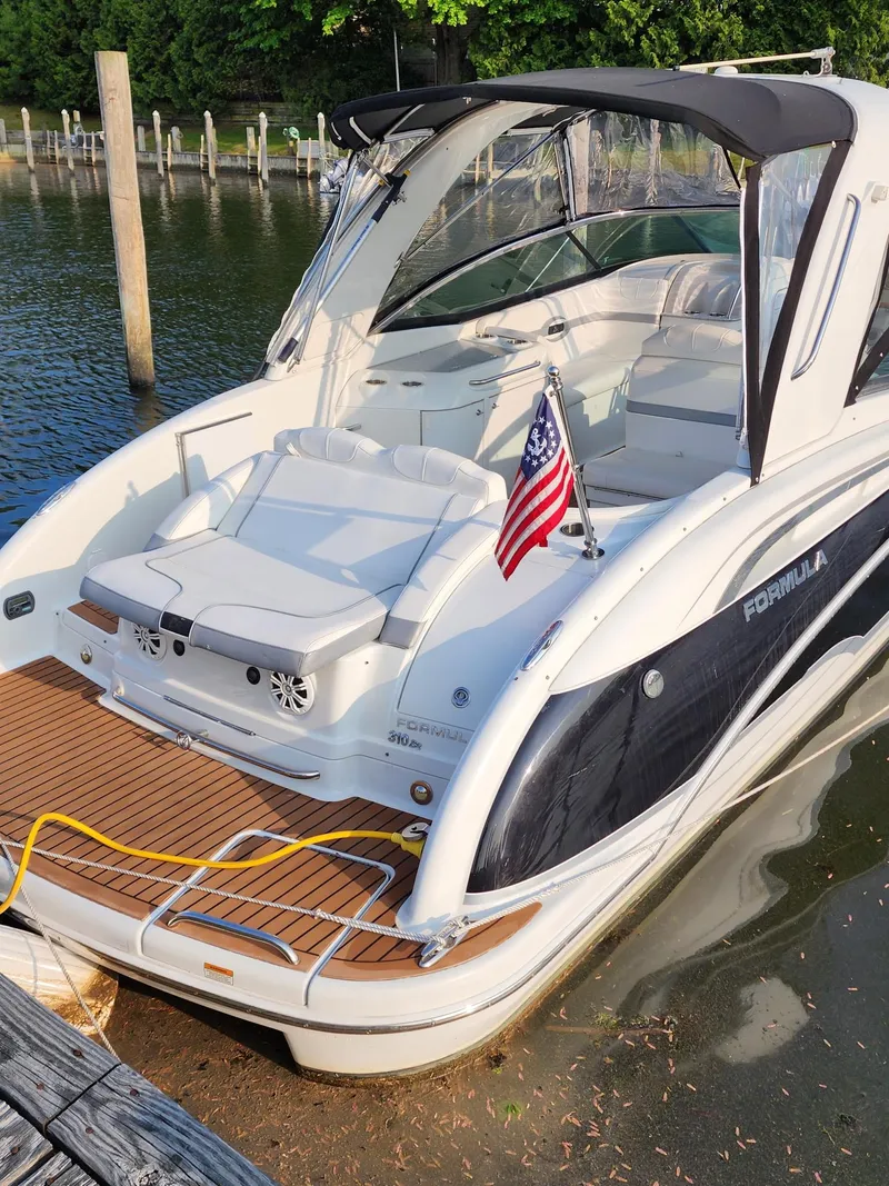 Slide: The Image of 2008 Formula 310 Bowrider boat docked, featuring sleek design and American flag. - 5
