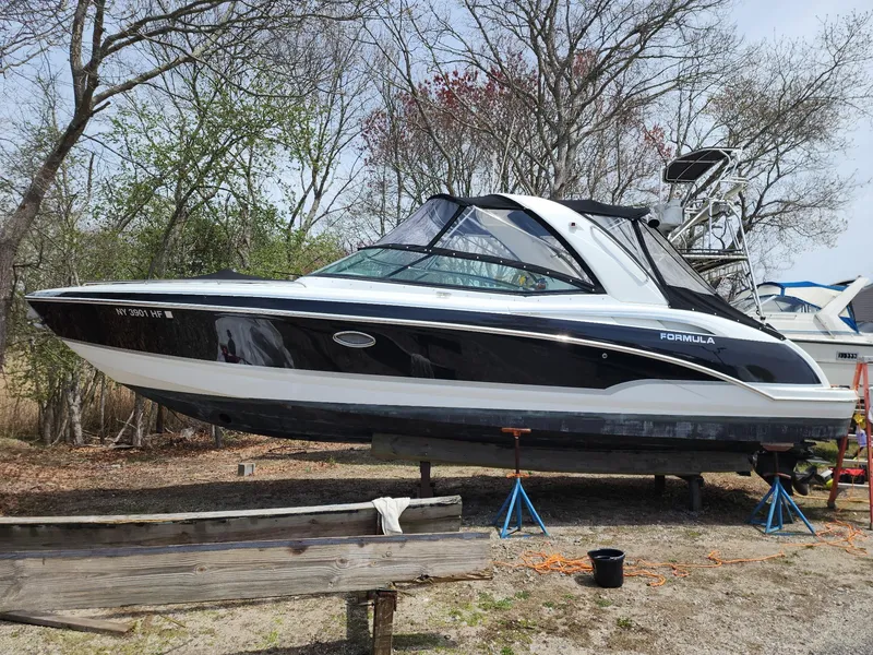 Slide: The Image of 2008 Formula 310 Bowrider boat on stands, surrounded by trees. - 8