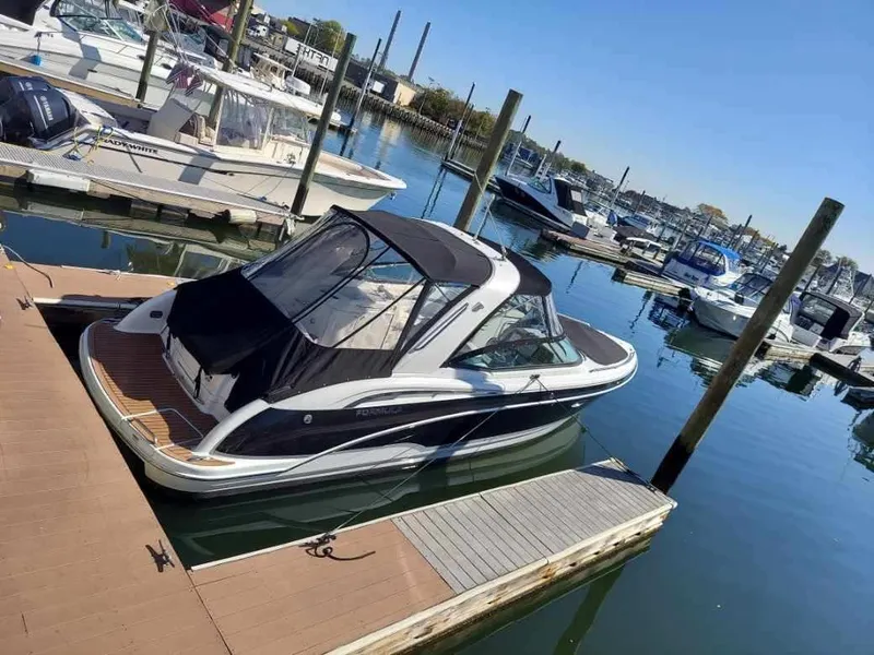 Slide: The Image of 2008 Formula 310 Bowrider docked at marina, featuring sleek design and black canopy. - 9