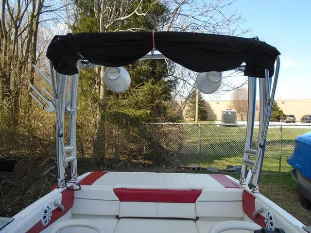 Slide: The Image of 2013 Bayliner 185 Bowrider with wakeboard tower and speakers, parked outdoors. - 11