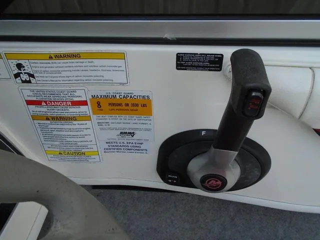 Slide: The Image of 2013 Bayliner 185 Bowrider control panel with capacity warnings and throttle lever. - 12