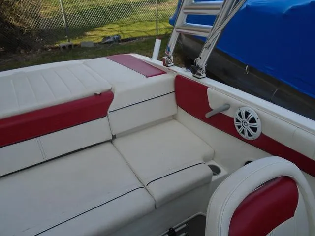 Slide: The Image of 2013 Bayliner 185 Bowrider interior with red and white seating, speaker, and ladder. - 16