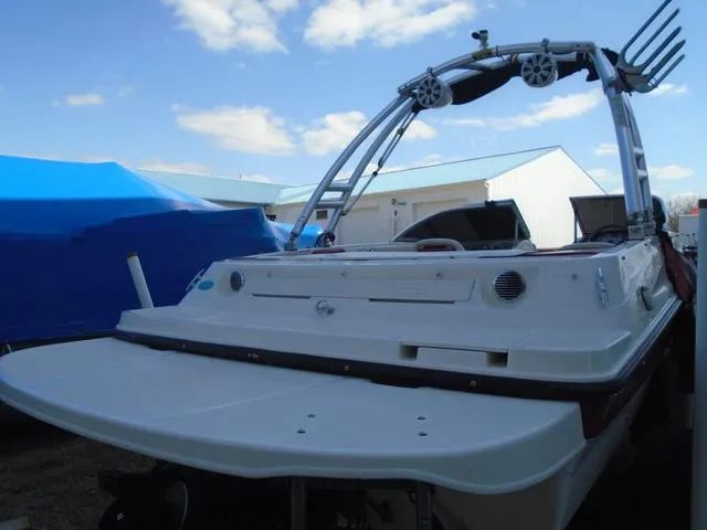 Slide: The Image of 2013 Bayliner 185 Bowrider boat with wakeboard tower, parked outdoors under blue sky. - 25