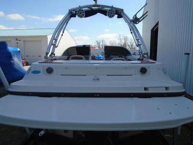 Slide: The Image of 2013 Bayliner 185 Bowrider boat with wakeboard tower, parked near a building. - 28