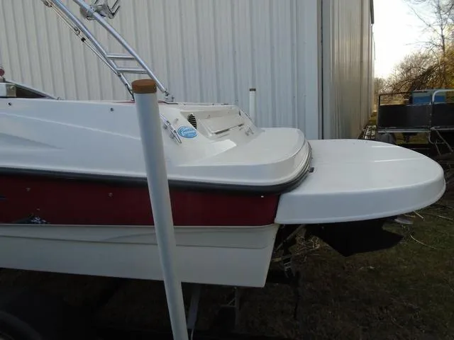 Slide: The Image of 2013 Bayliner 185 Bowrider boat, rear view, parked near a metal building. - 29