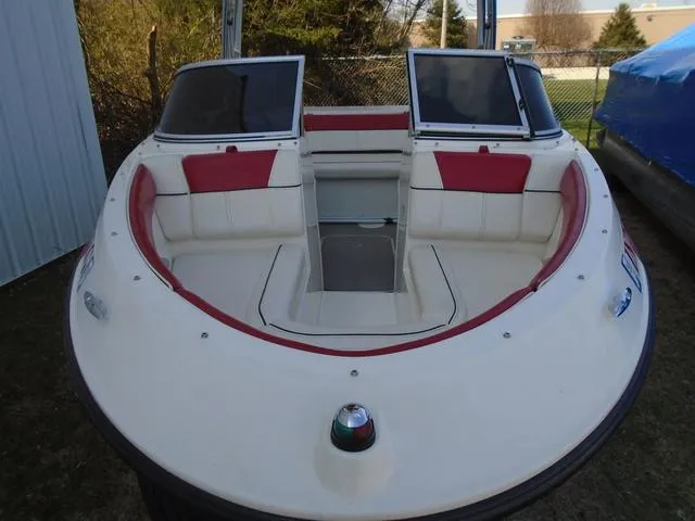 Slide: The Image of 2013 Bayliner 185 Bowrider boat with red and white seating, docked outdoors. - 30
