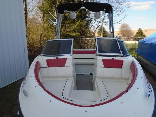 Slide: The Image of 2013 Bayliner 185 Bowrider boat with red and white seating, docked outdoors. - 31