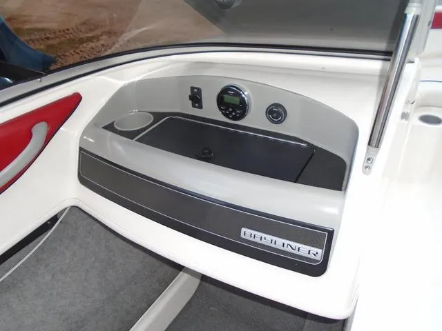 Slide: The Image of 2013 Bayliner 185 Bowrider dashboard with storage compartment and control panel. - 9