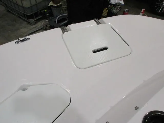 Slide: The Image of 2023 Hurricane SunDeck 187 IO boat deck with storage hatch, white finish, in a workshop setting. - 12