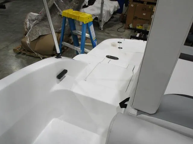Slide: The Image of 2023 Hurricane SunDeck 187 IO boat interior, featuring white seating and storage compartments. - 13