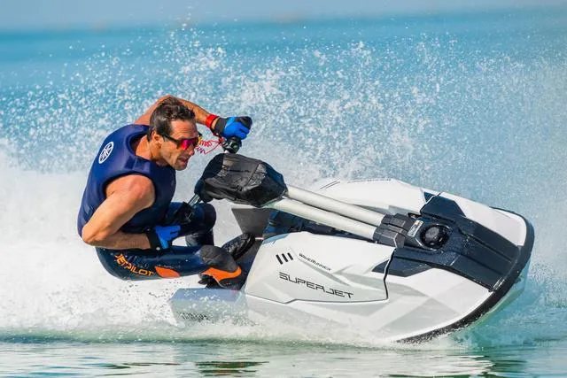 Slide: The Image of 2025 Yamaha WaveRunner SuperJet in action on water, rider leaning sharply. - 6