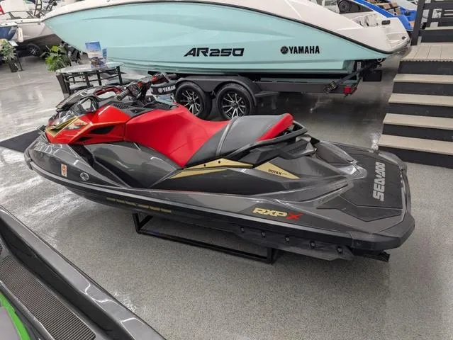 Slide: The Image of 2019 Sea-Doo RXP-X 300 in black and lava red on display indoors. - 5