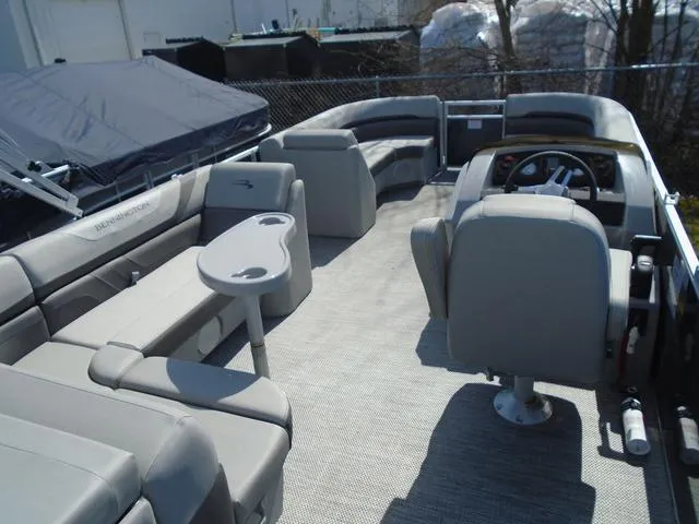 Slide: The Image of 2024 Bennington 21 SXL pontoon boat interior with gray seating and steering console. - 13