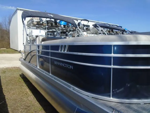 Slide: The Image of 2024 Bennington 21 SXL pontoon boat with blue exterior, docked outdoors. - 15