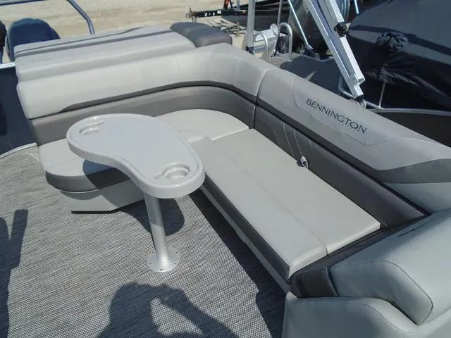 Slide: The Image of 2024 Bennington 21 SXL boat interior with gray seating and a small table. - 16