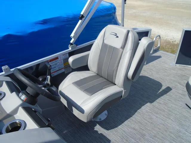 Slide: The Image of 2024 Bennington 21 SXL boat captain's chair with steering wheel, featuring gray upholstery and armrests. - 17