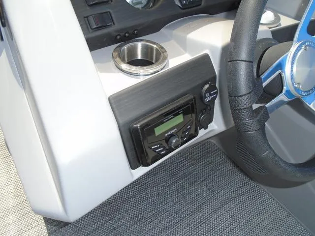 Slide: The Image of 2024 Bennington 21 SXL dashboard with steering wheel, cup holder, and audio controls. - 21