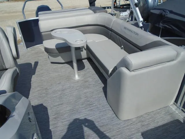 Slide: The Image of 2024 Bennington 21 SXL pontoon boat interior with gray seating and table. - 25