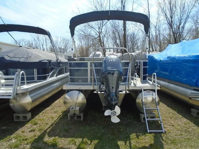 Slide: The Image of 2024 Bennington 21 SXL pontoon boat with outboard motor, parked on grass. - 28