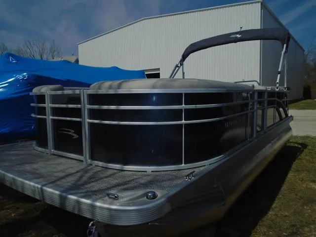 Slide: The Image of 2024 Bennington 21 SXL pontoon boat parked near a large building. - 5