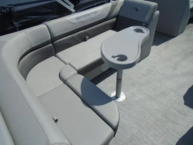 Slide: The Image of 2024 Bennington 21 SXL pontoon boat interior with gray seating and table. - 6