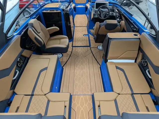 Slide: The Image of 2024 Yamaha Boats 255XD interior with tan and blue seating, modern dashboard, and spacious layout. - 4
