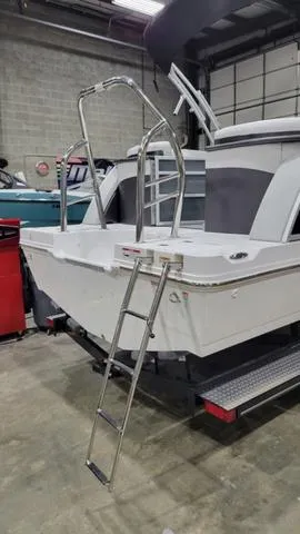 Slide: The Image of 2024 Hurricane FunDeck 2360 SBC OB boat with ladder in a garage setting. - 9