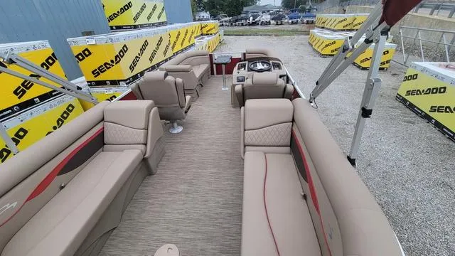 Slide: The Image of 2023 Bennington 22 SSR pontoon boat with beige seating, surrounded by Sea-Doo packaging. - 2