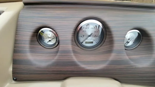 Slide: The Image of Dashboard of 2023 Bennington 22 SSR with wood finish and analog gauges. - 6