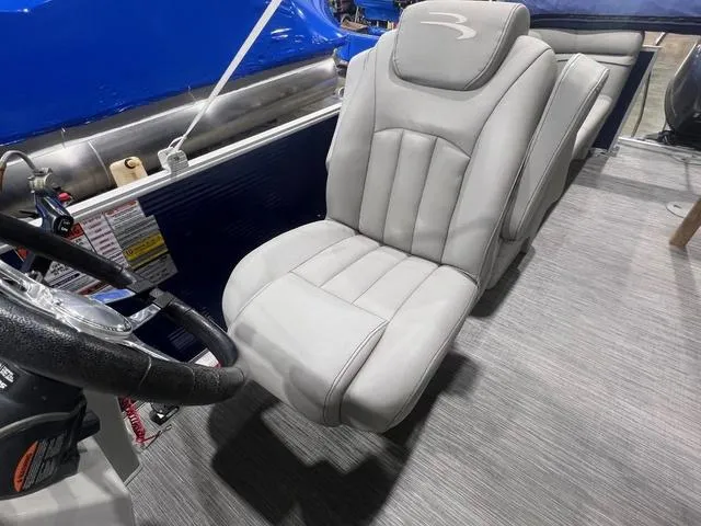 Slide: The Image of Captain's seat on 2023 Bennington 22 SSR pontoon boat, featuring sleek gray upholstery. - 10