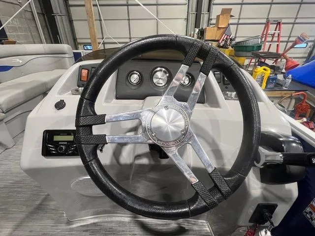 Slide: The Image of 2023 Bennington 22 SSR steering wheel and dashboard in a garage setting. - 13