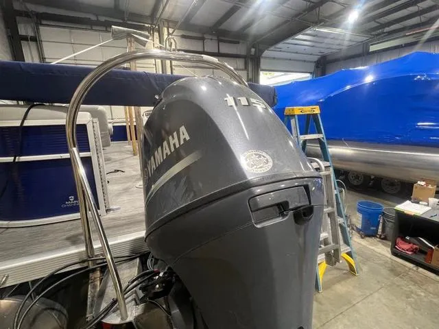 Slide: The Image of 2023 Bennington 22 SSR with Yamaha outboard motor in a boat workshop. - 15