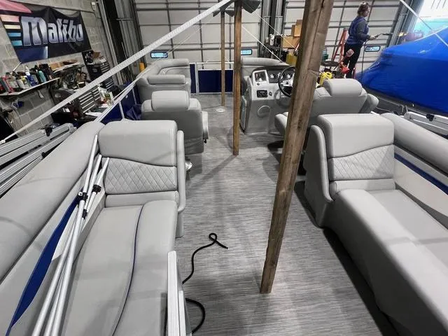 Slide: The Image of 2023 Bennington 22 SSR pontoon boat interior with gray seating in a garage setting. - 6