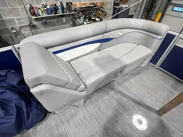 Slide: The Image of 2023 Bennington 22 SSR boat interior with gray seating and blue accents in a garage setting. - 8