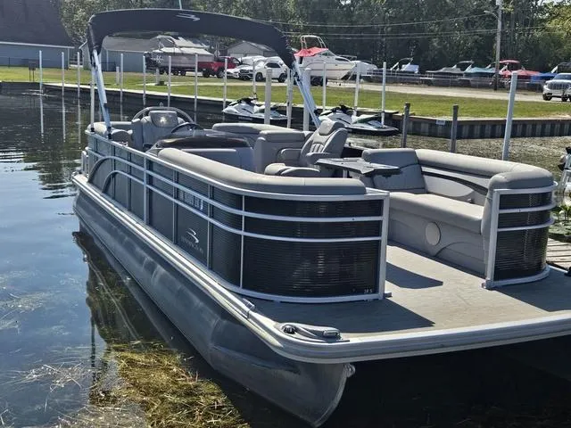 Slide: The Image of 2023 Bennington 24 SSR pontoon boat docked on a sunny day. - 1