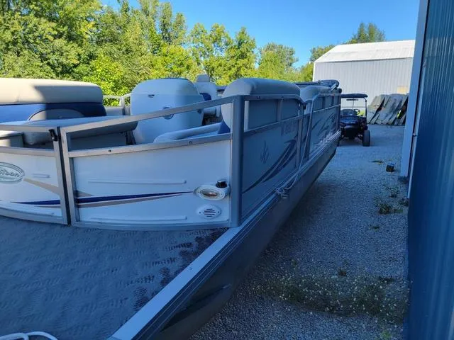 Slide: The Image of 2008 JC MFG Neptune 23 pontoon boat parked outdoors near a blue building. - 4