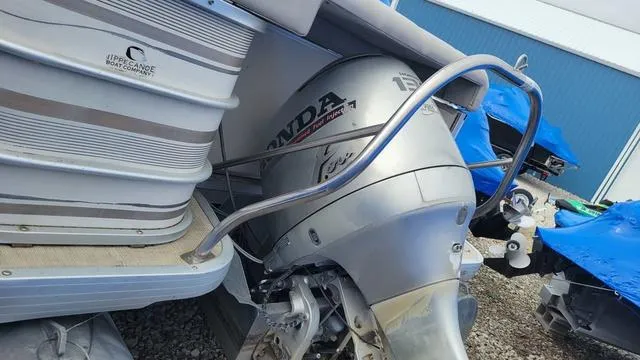 Slide: The Image of 2000 Godfrey Pontoons San Pan with Honda outboard motor, docked near blue tarp. - 10