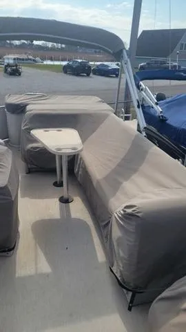 Slide: The Image of 2000 Godfrey Pontoons San Pan with covered seating and table, docked outdoors. - 12